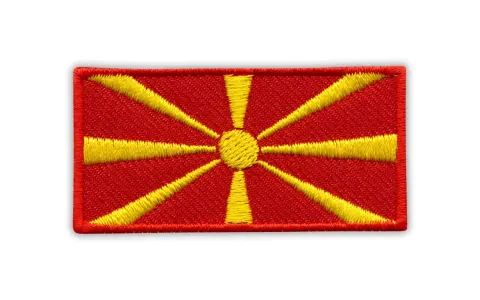 Naszywka z flagą Macedonii. Czerwone tło z żółtym słońcem i promieniami.