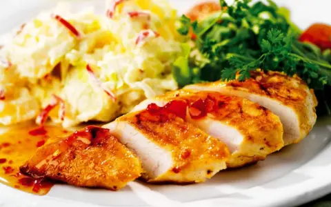 En saftig kycklingfilé serveras med en krämig fransk potatissallad med kyckling och en fräsch grönsallad.