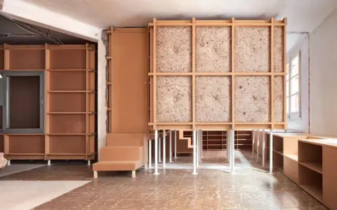 Progetto di ristrutturare casa con 10.000 euro: struttura in legno grezzo, pannelli isolanti e arredi modulari in cartone.