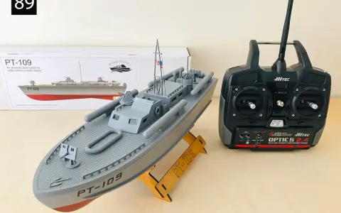Modell eines Patrouillenboots PT-109 auf einem Holzständer, daneben eine Fernsteuerung.
