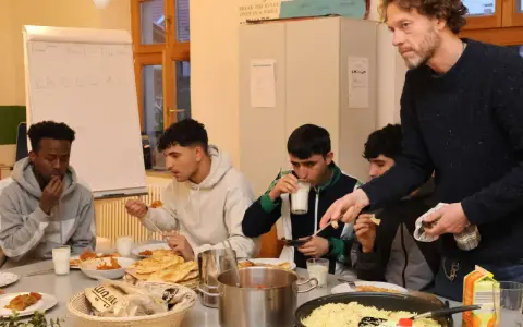 Männer essen gemeinsam während des Ramadans. Auf dem Tisch stehen Reis, Brot und Getränke.