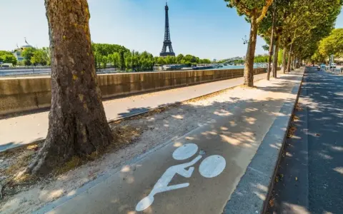 Radweg am Seine-Ufer mit Blick auf den Eiffelturm. Ein Zeichen für die moderne Stadtentwicklung in Paris, die auf nachhaltige Mobilität setzt.