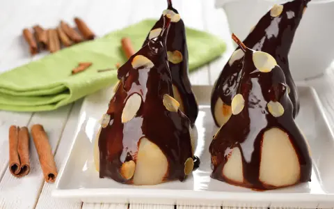 Poires pochées nappées de chocolat noir et d'amandes effilées, une délicieuse recette de poire Belle Hélène.