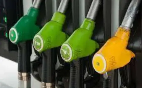 Pistolets de pompe à essence, certains verts marqués E10, un jaune. L'image évoque la transition pour convertir diesel en biodiesel.