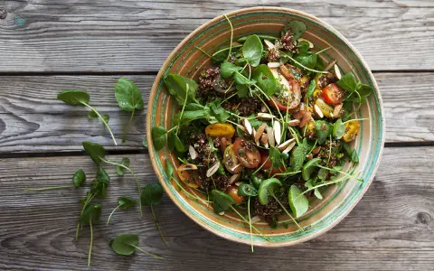 En härlig quinoa sallad med tomater, gröna blad och mandel. Perfekt för ett snabbt och nyttigt quinoa recept.