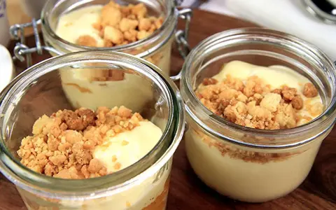Tre små glasburkar med len vit chokladmousse toppad med smulig crumble. Perfekt för en söt stund.