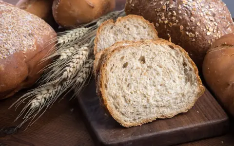 Różnorodne pieczywo, w tym kromki chleba pełnoziarnistego, które sugerują, jakie pieczywo jest dietetyczne.