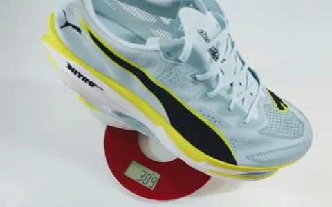Leichter Laufschuh in Hellblau mit gelben und schwarzen Akzenten auf einer Waage. Das Gewicht der Schuhe beträgt 389 Gramm.