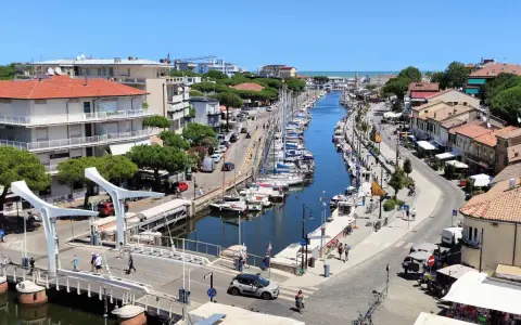 Passeggiata sul canale di Cervia, con barche ormeggiate e negozi. Un'ottima idea per scoprire cosa fare a Cervia in una giornata di sole.