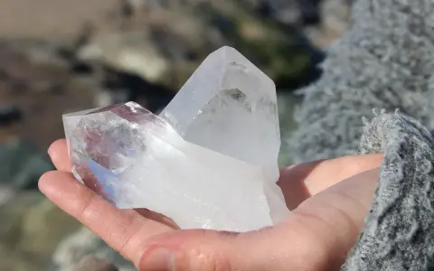 Dłoń trzyma dwa kryształy kwarcu, symbolizujące kamień sukcesu.