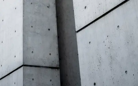Superficie de hormigón con fibra de polipropileno, mostrando texturas y juntas oscuras entre bloques.