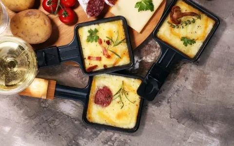 Pyszne, roztopione sery z dodatkami w patelenkach do raclette. Idealne na wspólne wieczory, gdy zastanawiasz się, co na raclette.