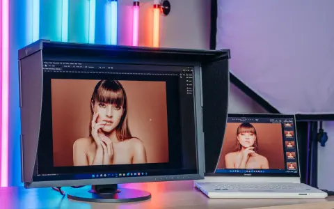 Dwa monitory pokazują portret kobiety. Większy monitor EIZO wyświetla obraz w rozdzielczości 2k, a obok laptop ConceptD.