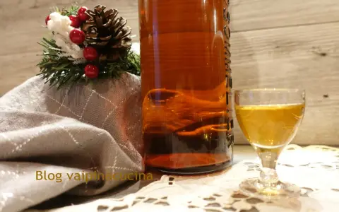 Liquore genziana ricetta: bottiglia ambrata, bicchierino dorato e decorazione natalizia.