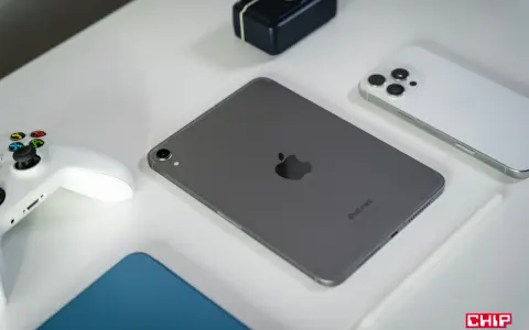 Szary iPad mini, biały kontroler do gier, biały iPhone i rysik na białym tle.