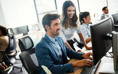 Un equipo colabora en la oficina, mostrando una excelente **comunicación en equipo** mientras trabajan en sus ordenadores.