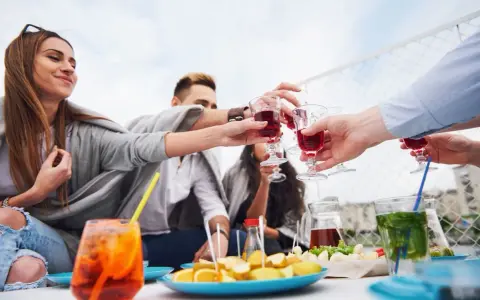 Grupa przyjaciół wznosi toast czerwonymi drinkami. Czy to już czas na digestif co to?