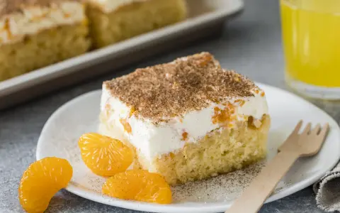Ein Stück saftiger Fantakuchen mit cremiger Füllung und Mandarinenstücken, bestreut mit Zimt. Perfekt für das Fantakuchen Rezept!