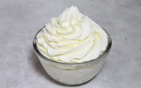 Chantilly au robot pâtissier, aérienne et onctueuse, dressée en rosace dans un bol en verre. Parfait pour garnir vos desserts.