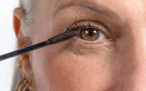 Application de mascara sur des cils. On se demande combien de temps dure un mascara avant de devoir le remplacer.