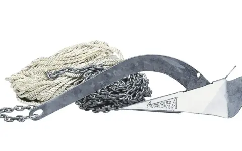 Ancre à jas ancienne, avec chaîne et cordage blanc. Le nom "KOBRA" est gravé sur l'ancre.