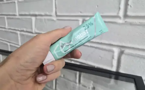 Dłoń trzyma tubkę serum niacynobaza 25%. Wiele pozytywnych opinii o tym produkcie.