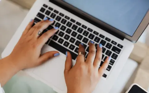 Mani che digitano su un laptop, forse per un corso di **università Pegaso**.