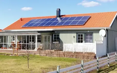 Hus med solpaneler på taket. Undrar du över batteri till solceller pris?