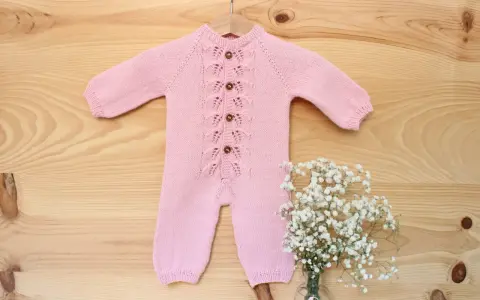 Precioso pelele punto bebé rosa con botones de madera y delicado encaje. Perfecto para un recién nacido.