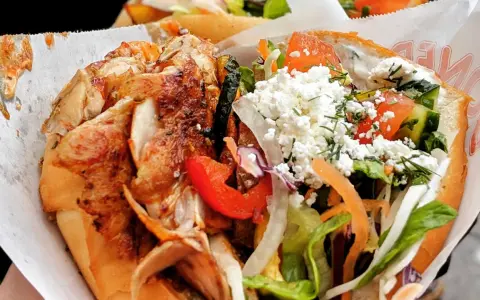 Kebab z kurczakiem w bułce z warzywami i serem feta.