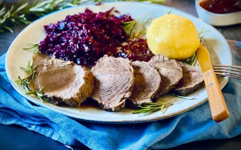 Saftiger Rinderbraten, serviert mit Rotkohl und Klößen – ein köstliches rinderbraten rezept für ein Festmahl.