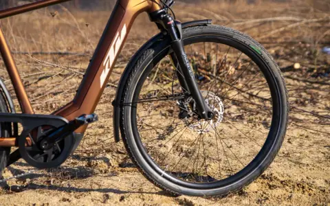 Vorderreifen und Federgabel eines braunen KTM Macina Style E-Bikes. Der Unterschied zwischen dem KTM Macina Style 720 und 730 liegt in den Details.