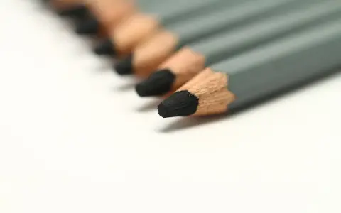 Una fila de lápices duros de grafito gris, listos para dibujar o escribir.