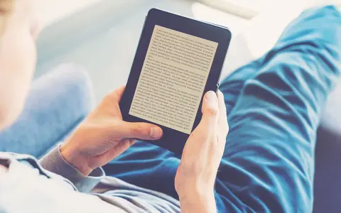 Osoba czyta książki na czytniku e-booków. Wygodny audiobook książki w cyfrowej formie.