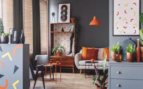 Nowoczesny salon z kanapą, fotelami i dekoracjami w kolorze morelowym.