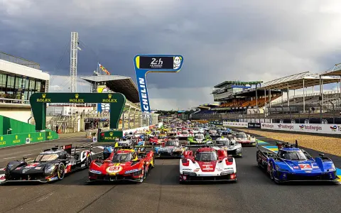 Startaufstellung für das 24-Stunden-Rennen von Le Mans. Rennwagen stehen bereit, die Spannung ist greifbar.