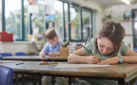 Dziewczynka z piegami skupiona na rysowaniu, obok niej chłopiec. Czy to zadanie na średnią ocenę 4?