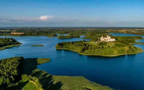 Malowniczy wschód Polski nad jeziorem, z wyspą i klasztorem.