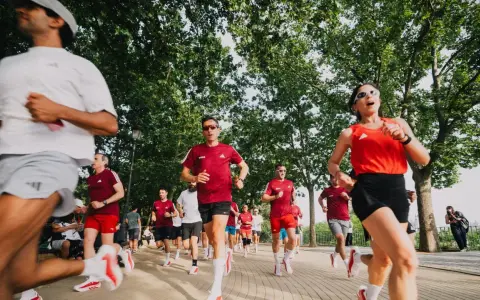 Corredores entrenan para el maratón Madrid 2026 en un día soleado, bajo la sombra de árboles frondosos.