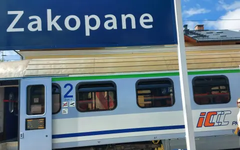 Niebieski znak "Zakopane" nad pociągiem PKP Intercity z numerem wagonu 2.