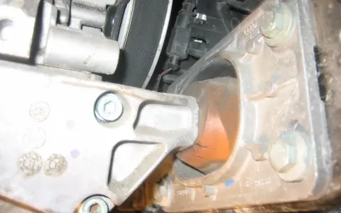 Zużyta poduszka silnika w Audi p1577. Widoczne pęknięcia gumy i metalowe elementy mocujące.