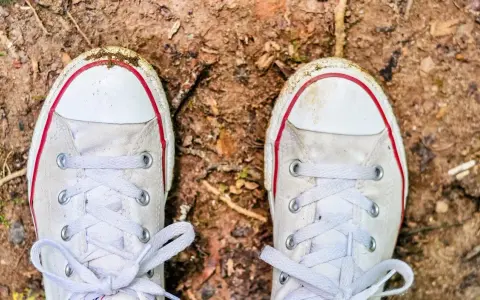 Brudne białe trampki na ziemi. Czas dowiedzieć się, jak wyczyścić białe podeszwy, by znów lśniły!