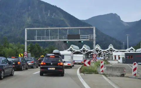 Korki na autostradzie przed punktem poboru opłat z widokiem na góry.