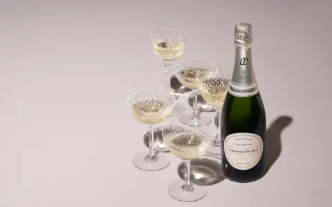 Flasche Laurent-Perrier Champagner neben gefüllten Gläsern. Ein süßer Champagner für besondere Anlässe.