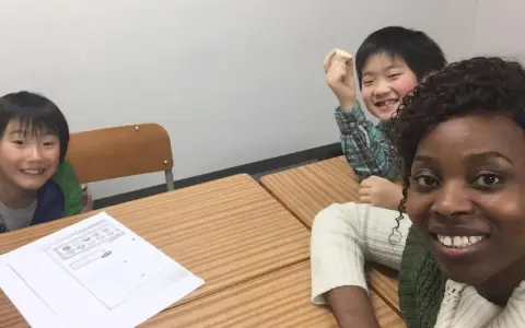 Fröhliche Kinder lernen Englisch. Eine Lehrerin gibt Nachhilfe auf Englisch.