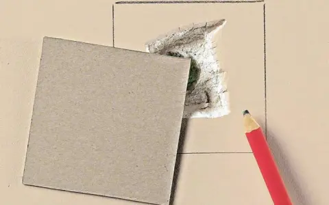 Kartonowy plaster i ołówek czekają, by pokazać, jak załatać dużą dziurę w ścianie.