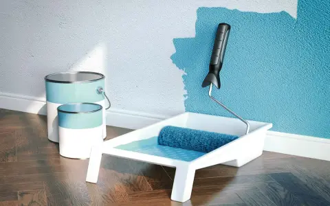 Latas de pintura plástica acrílica y rodillo listo para dar vida a una pared azul.