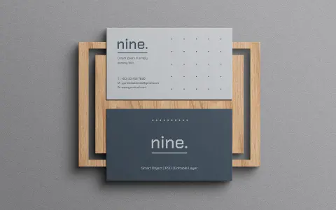 Dos tarjetas de visita minimalistas, una gris y otra azul oscuro, apiladas sobre un marco de madera.