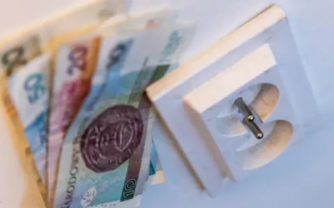 Polskie banknoty leżą obok gniazdka elektrycznego. Czy to symbolizuje rachunki za prąd? Billing co to?