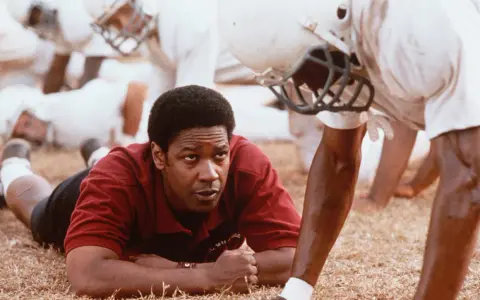 Denzel Washington, allenatore in un film sportivo, ispira la sua squadra. Storie vere di trionfo e determinazione.